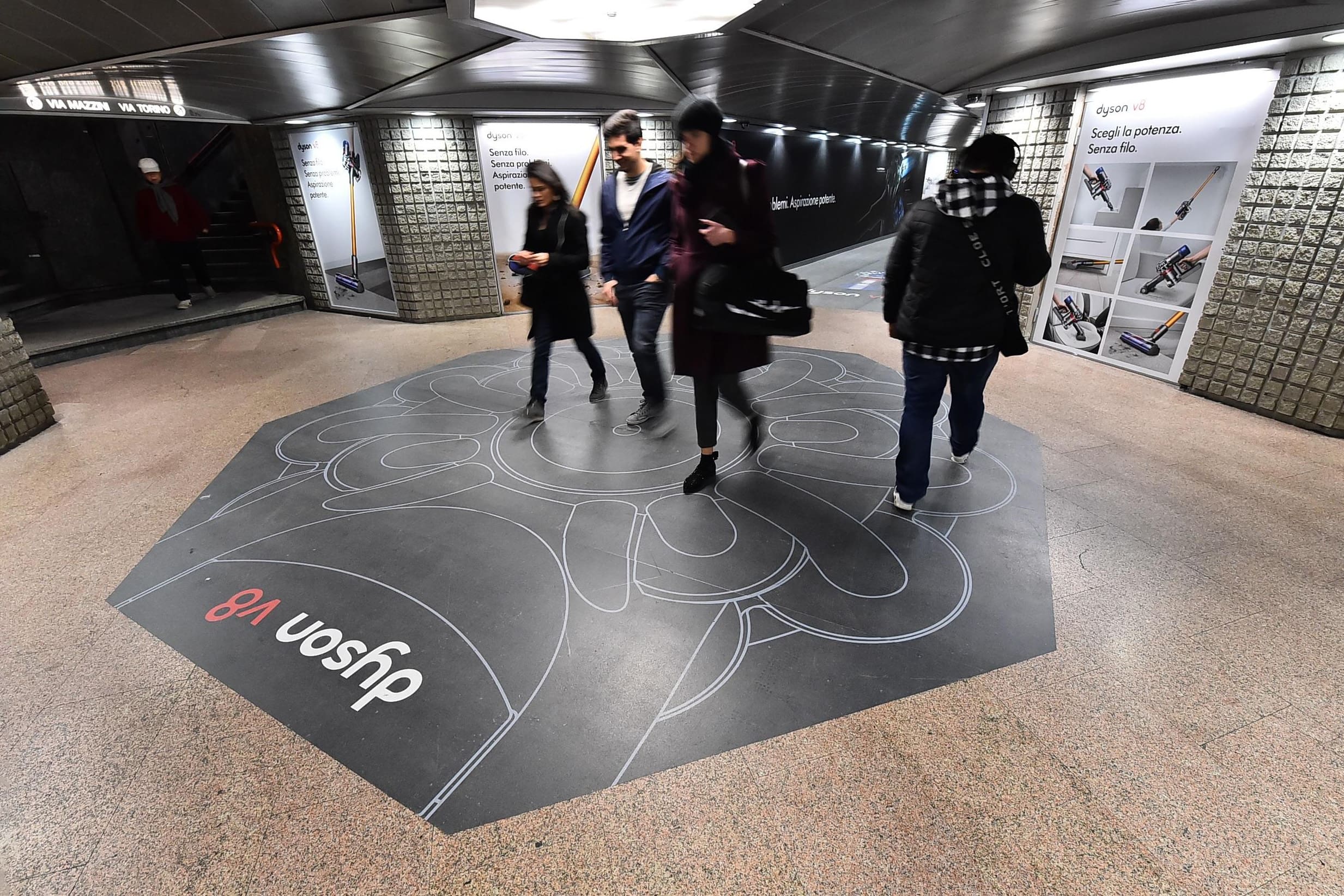 Dyson V8 out-of-home advertising campaign featuring a striking floor design in a busy subway station. - Alexi Hall